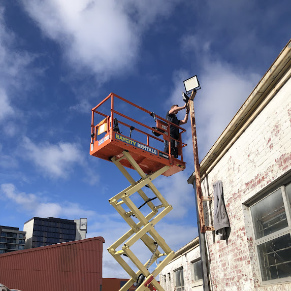 Commercial floodlight installation on scissor lift — S+ Electrical Services Melbourne