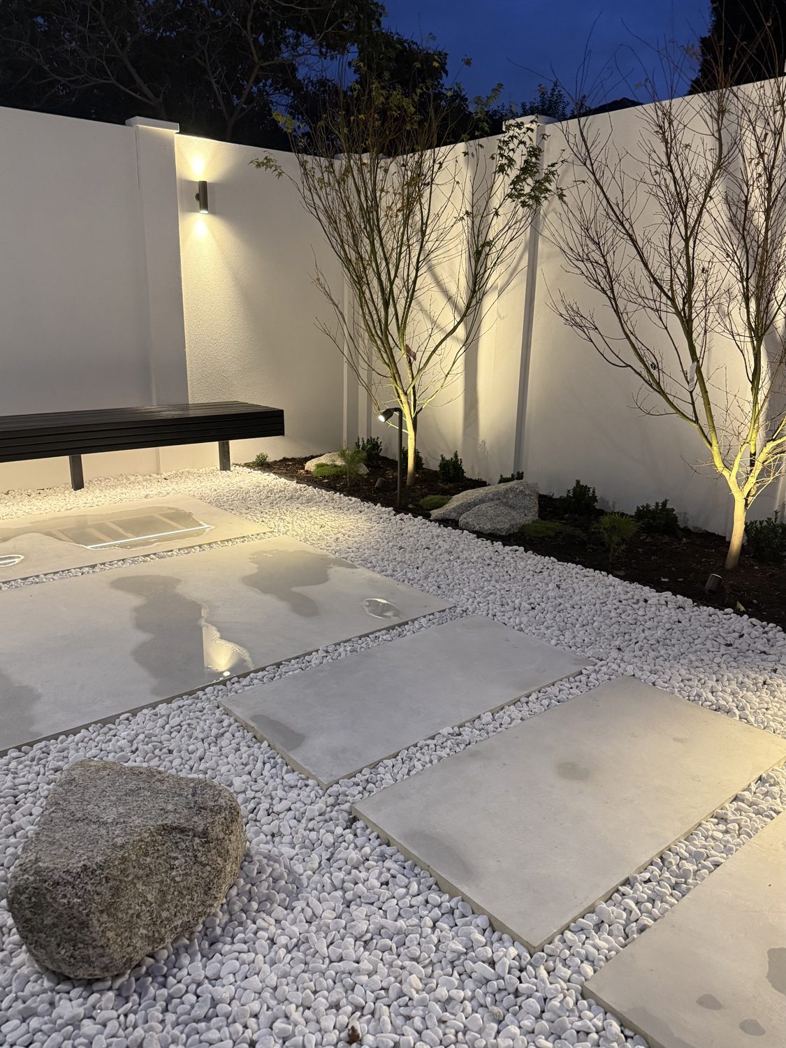 Japanese-style garden lighting with white pebble and uplit maples